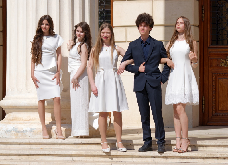 Boy posing with four girl on stairs
